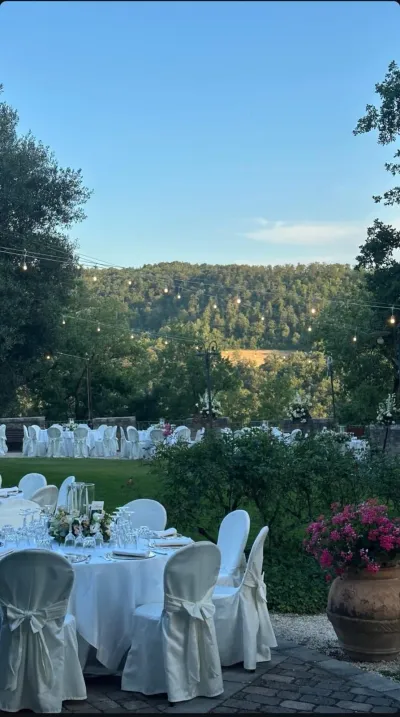 Tavoli rotondi allestiti nel giardino di Villa Torranca, con vista sulle colline umbre