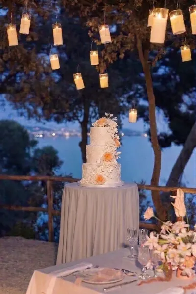 Torta nuziale sotto le lanterne sospese con vista sul mare
